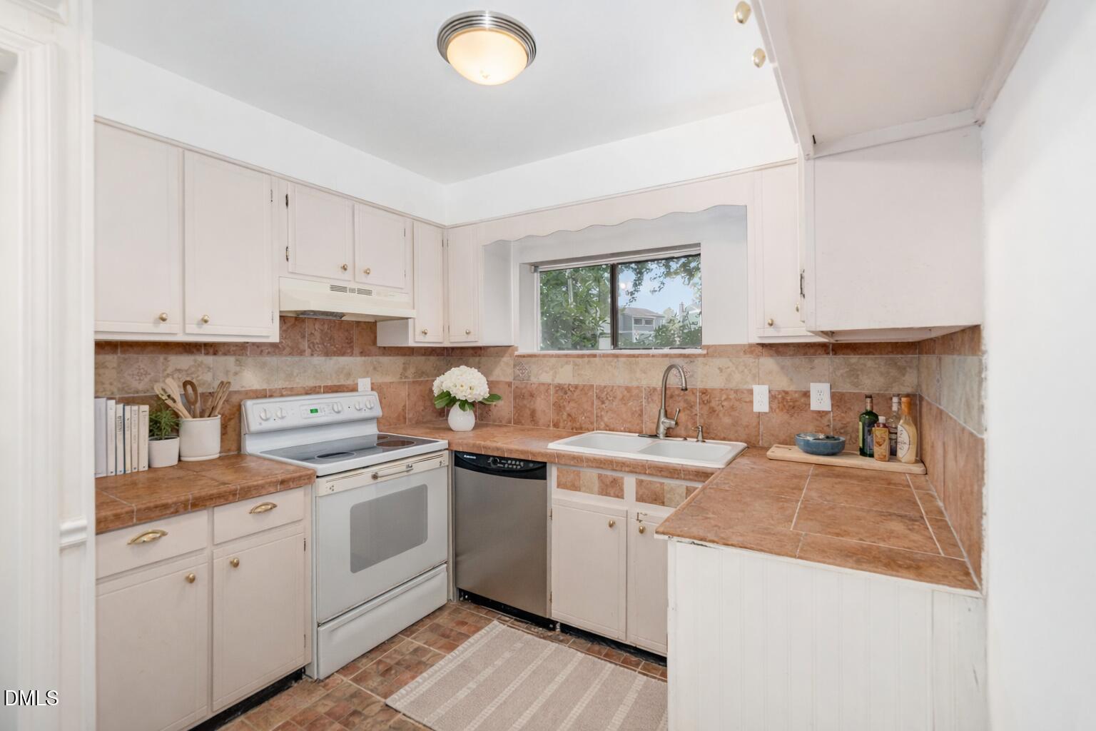5920 Farm Gate Road Raleigh, NC 27606 - Photo 6 of 16 a kitchen with a sink a stove and cabinets