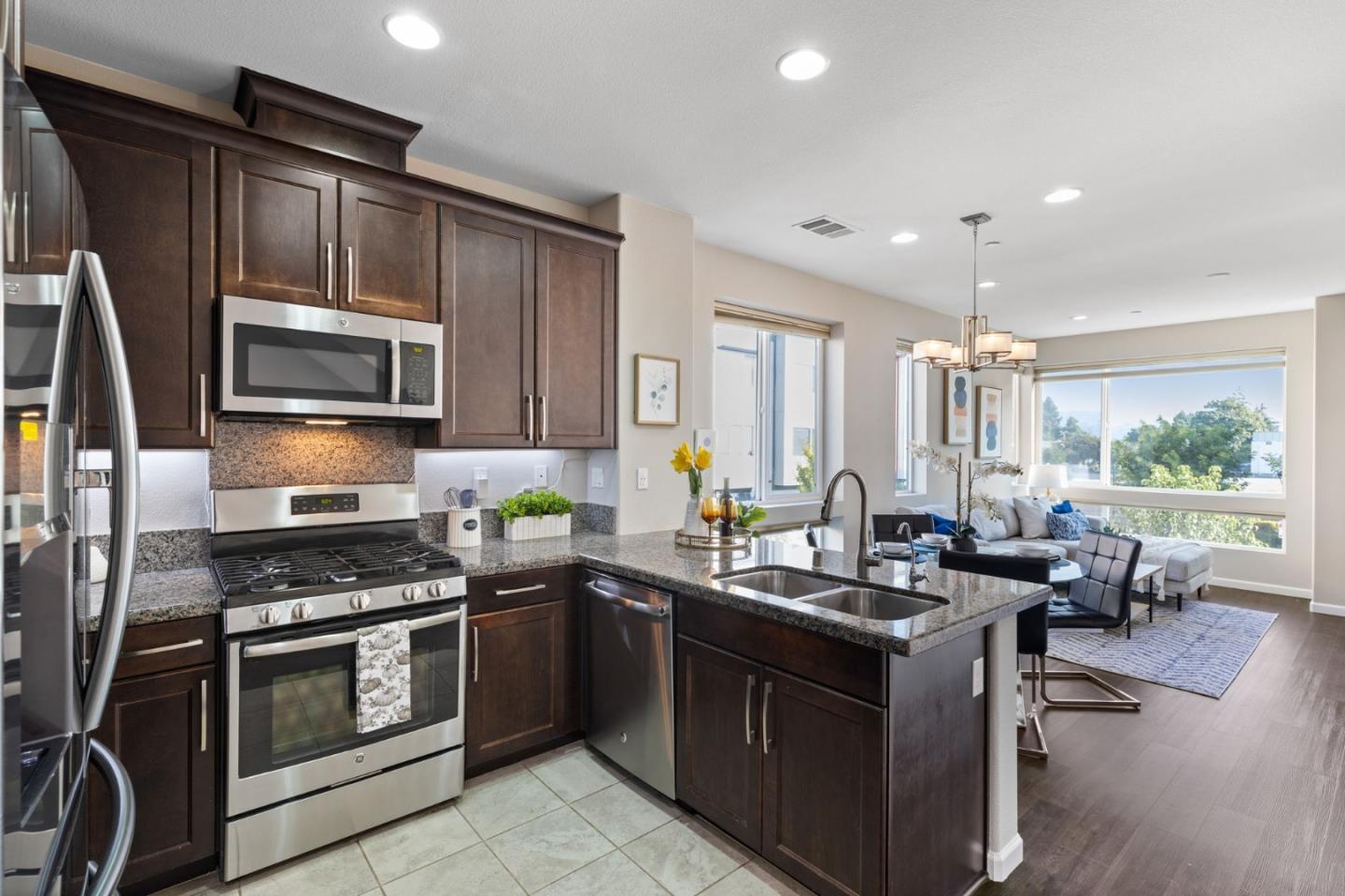 402 Ellicott Loop San Jose, CA 95123 - Photo 9 of 33 a kitchen with stainless steel appliances granite countertop a stove a sink dishwasher a microwave oven with granite countertops and couches