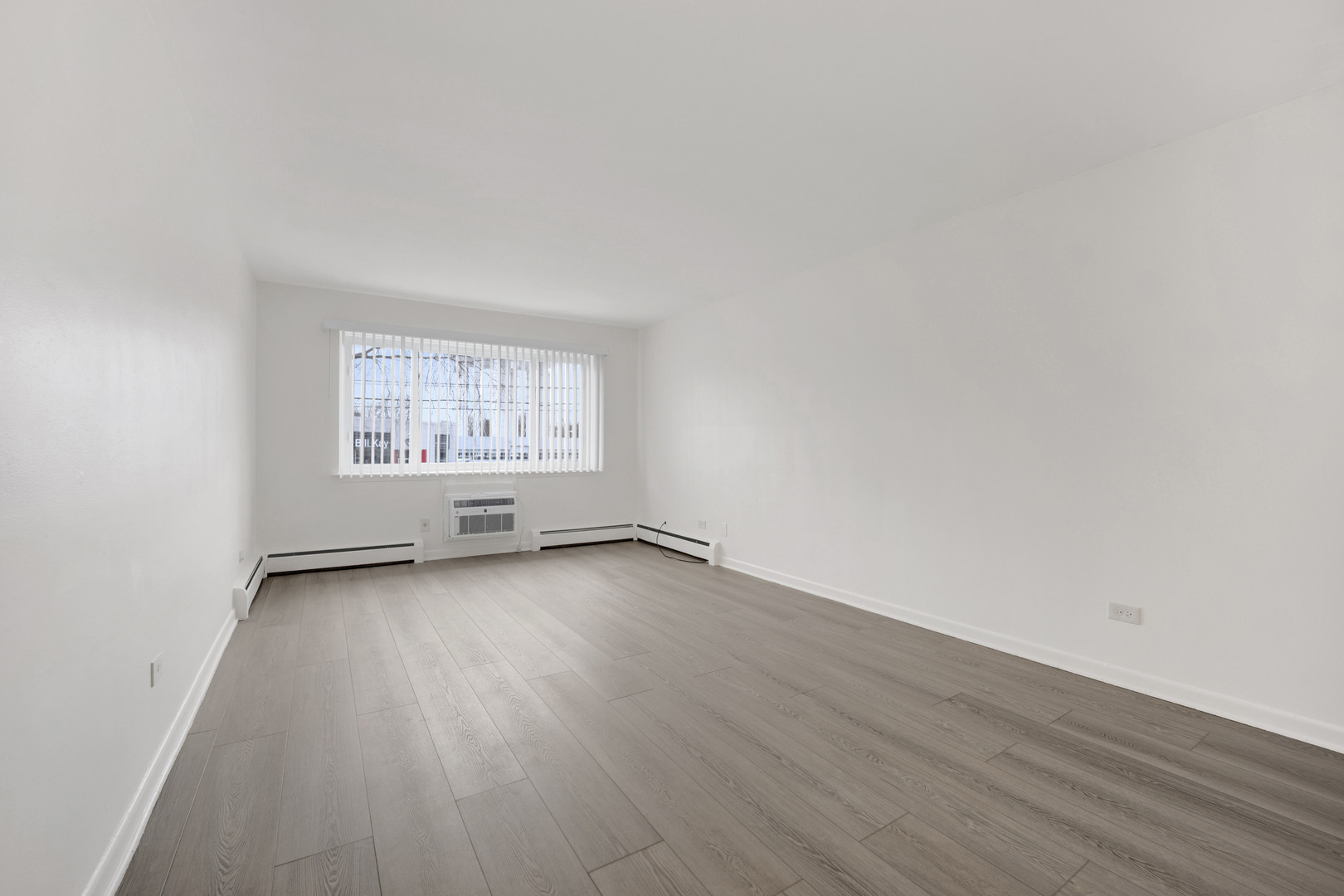 1608 Ogden Avenue, Unit 1E Downers Grove, IL 60515 - Photo 17 of 18 an empty room with wooden floor and windows
