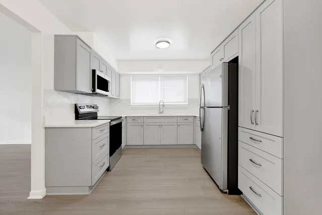 a kitchen with white cabinets and stainless steel appliances