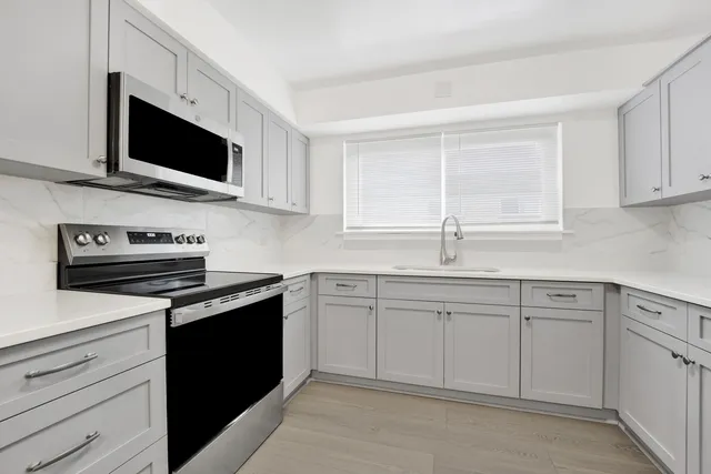 a kitchen with granite countertop a sink and a stove top oven