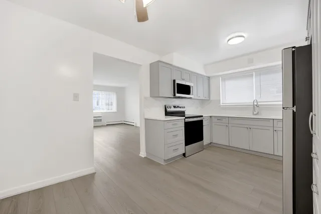 a kitchen with white cabinets and white appliances