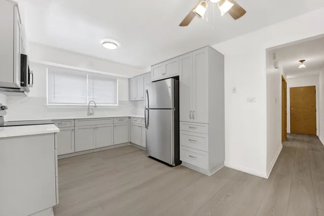 a kitchen with a refrigerator sink and cabinets