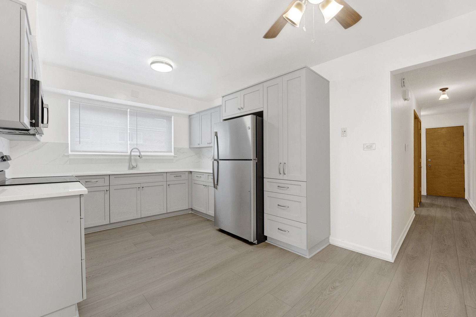 1608 Ogden Avenue, Unit 1E Downers Grove, IL 60515 - Photo 6 of 18 a kitchen with a refrigerator sink and cabinets