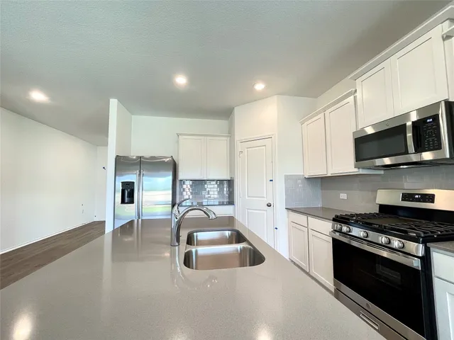 a kitchen with kitchen island a sink stainless steel appliances and cabinets