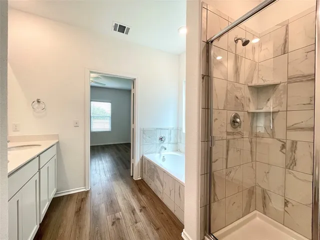 a spacious bathroom with a bathtub sink and mirror