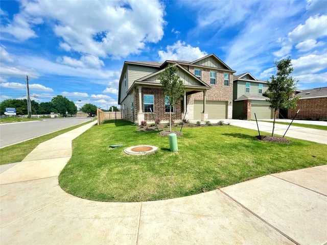 a view of a house with a big yard potted plants and large trees