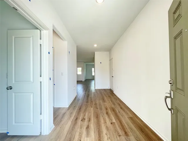 a view of a hallway with wooden floor