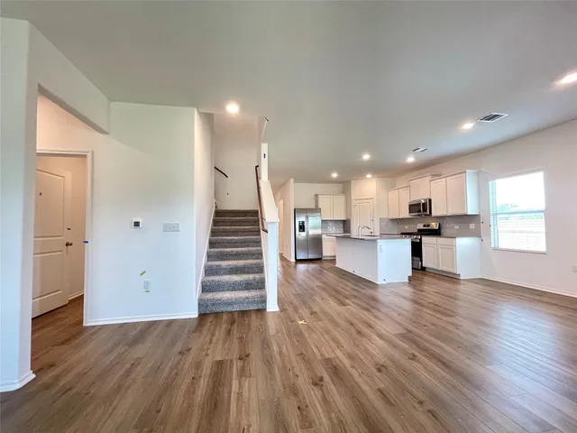 a view of kitchen with wooden floor and electronic appliances
