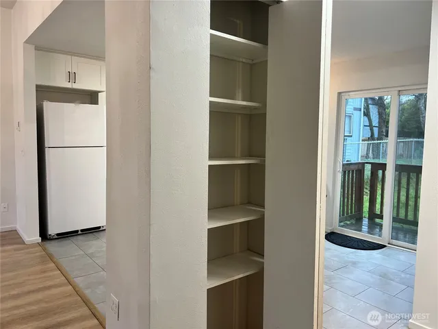 wooden floor in an empty room with a chandelier fan