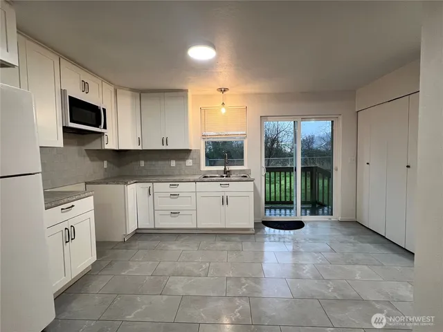 a kitchen with cabinets appliances a sink and a counter top space