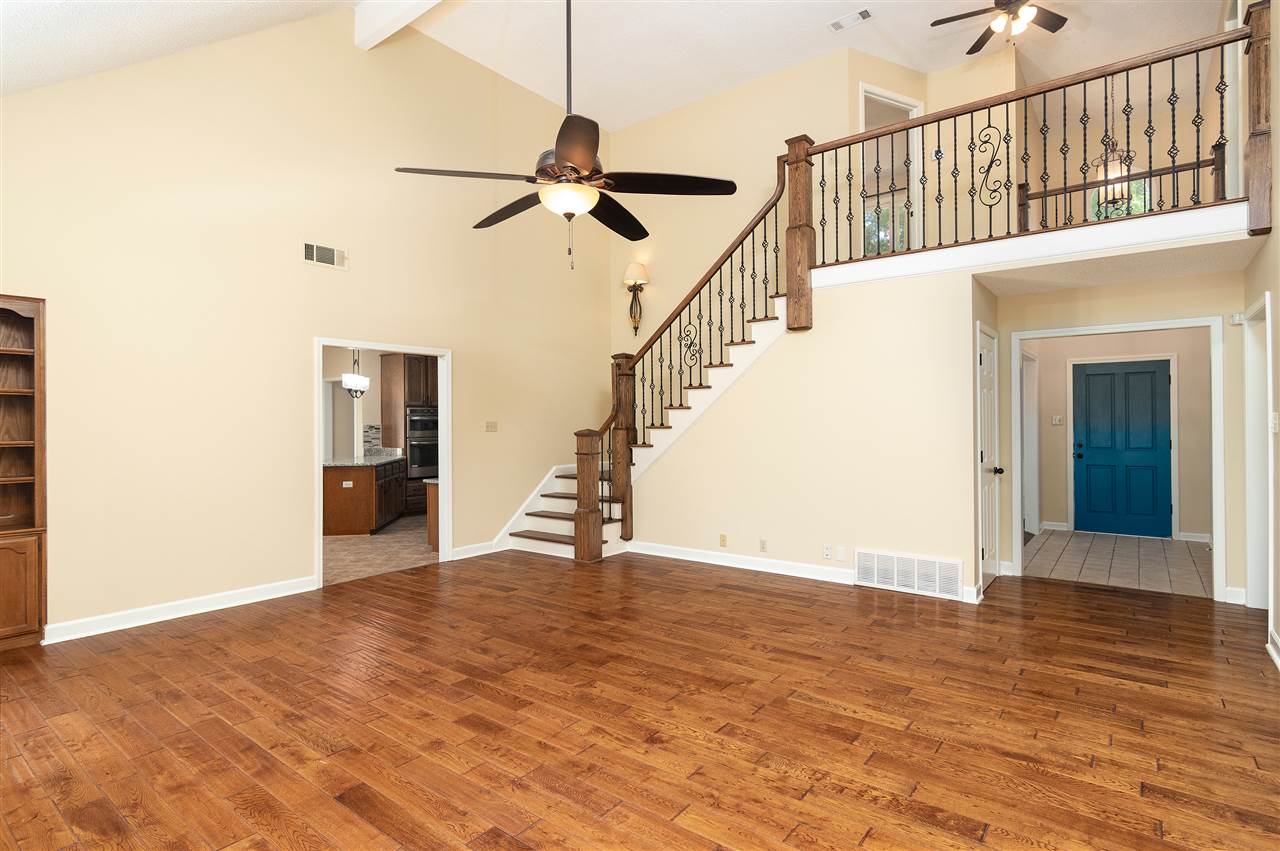 6945 Deerfield Road Bartlett, TN 38135 - Photo 3 of 25 Large den with hardwood flooring and gas fireplace. Built in bookshelves and storage.