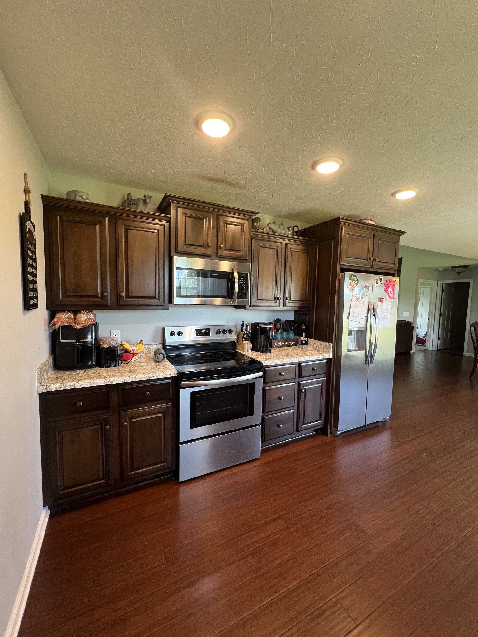 1288 Mt Olive Road Westmoreland, TN 37186 - Photo 6 of 16 a kitchen with stainless steel appliances granite countertop a stove top oven a sink dishwasher a refrigerator and a microwave oven on the wooden floor