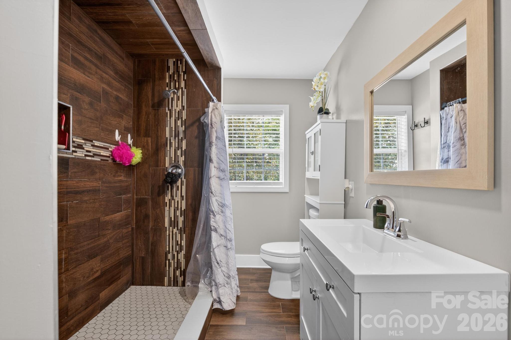 2076 Connelly Springs Road Lenoir, NC 28645 - Photo 23 of 47 a bathroom with a sink a toilet a shower and a mirror