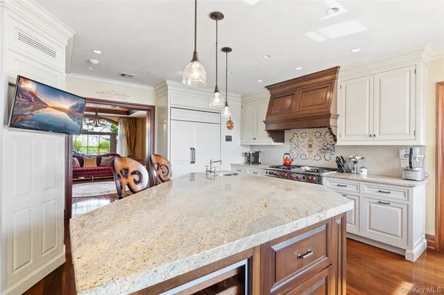 a view of a kitchen with kitchen island a sink a counter appliances and cabinets