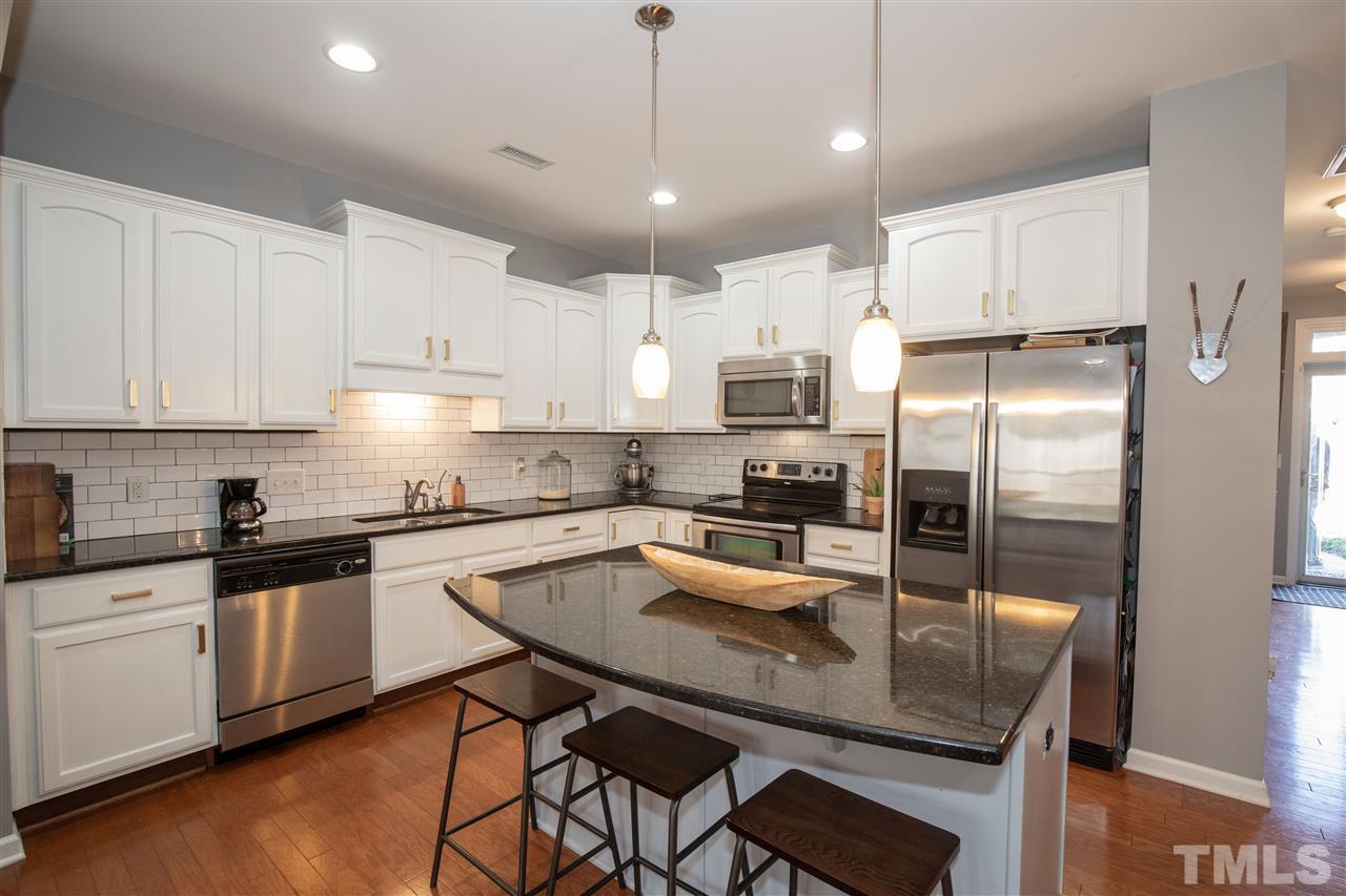2441 Memory Ridge Drive Raleigh, NC 27606 - Photo 5 of 21 a kitchen with granite countertop a center island appliances and cabinets