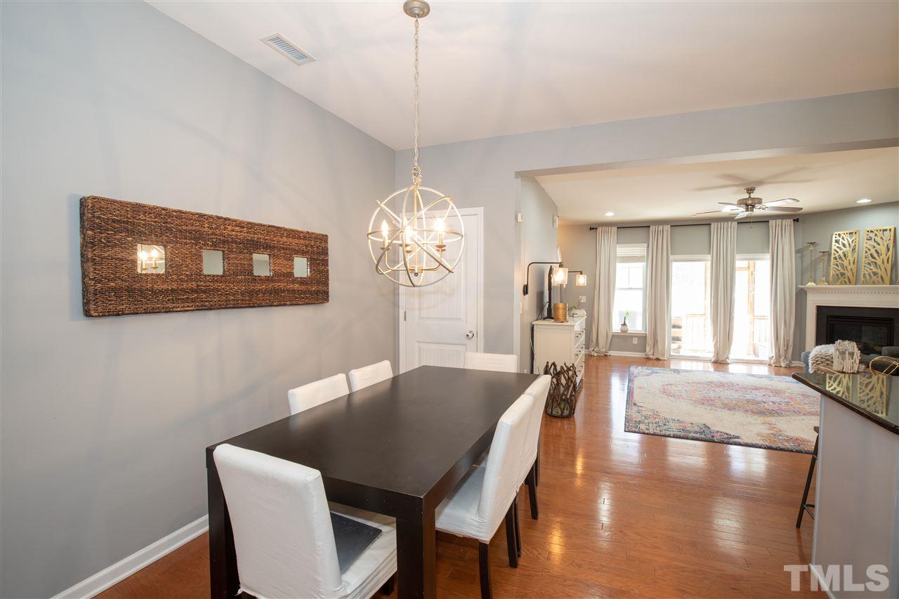 2441 Memory Ridge Drive Raleigh, NC 27606 - Photo 7 of 21 a dining room with wooden floor a chandelier a wooden table and chairs