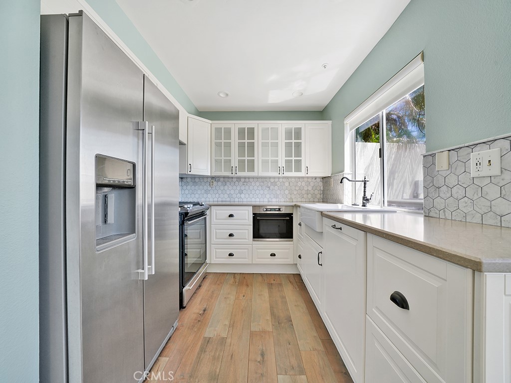 604 Via Espiritu San Clemente, CA 92672 - Photo 12 of 50 a large white kitchen with granite countertop a large window and stainless steel appliances