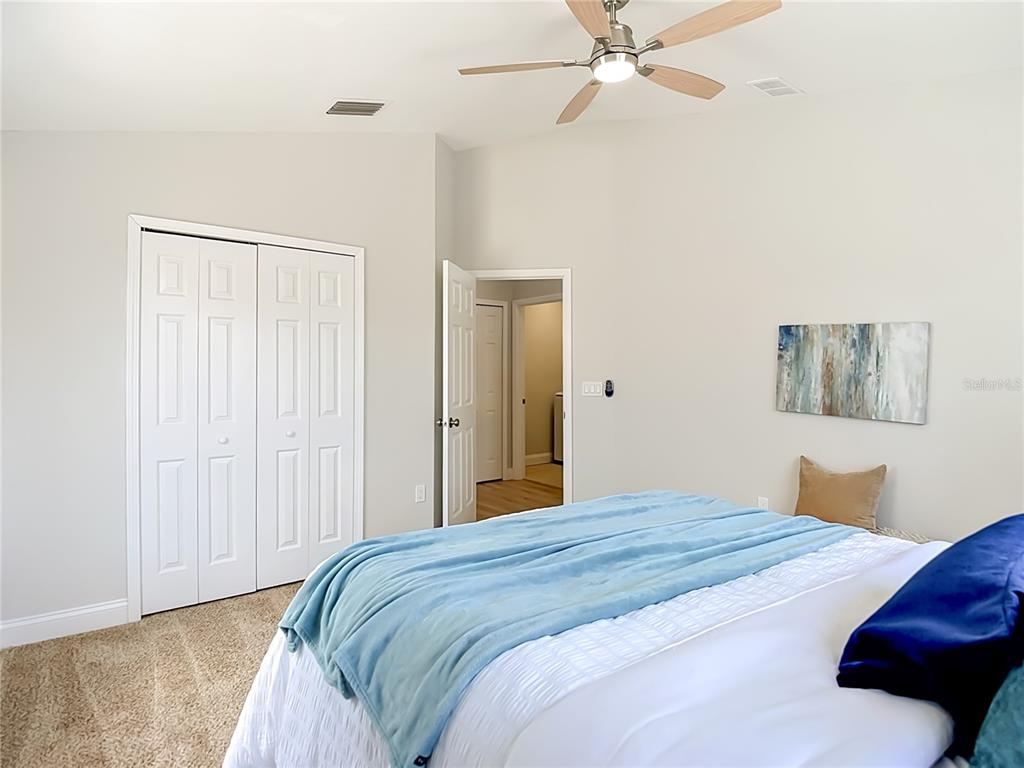 5310 Anhinga Trail New Port Richey, FL 34653 - Photo 20 of 27 a bedroom with a large bed and a chandelier fan