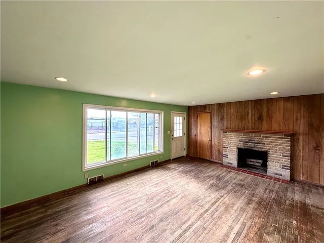an empty room with windows and fireplace