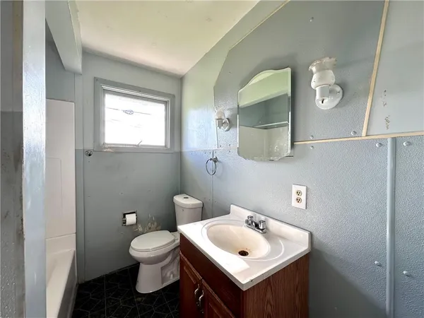 a bathroom with a toilet sink and mirror