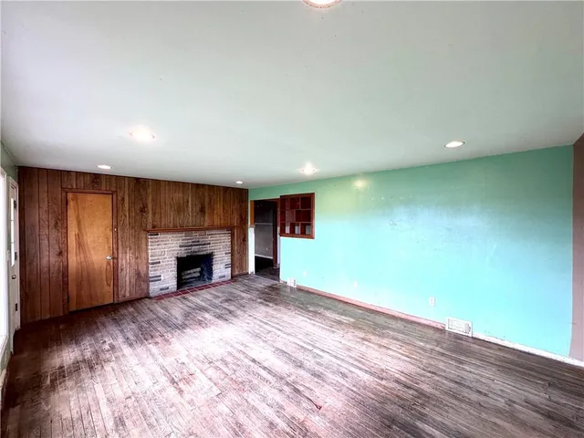 a view of empty room with wooden floor and fireplace