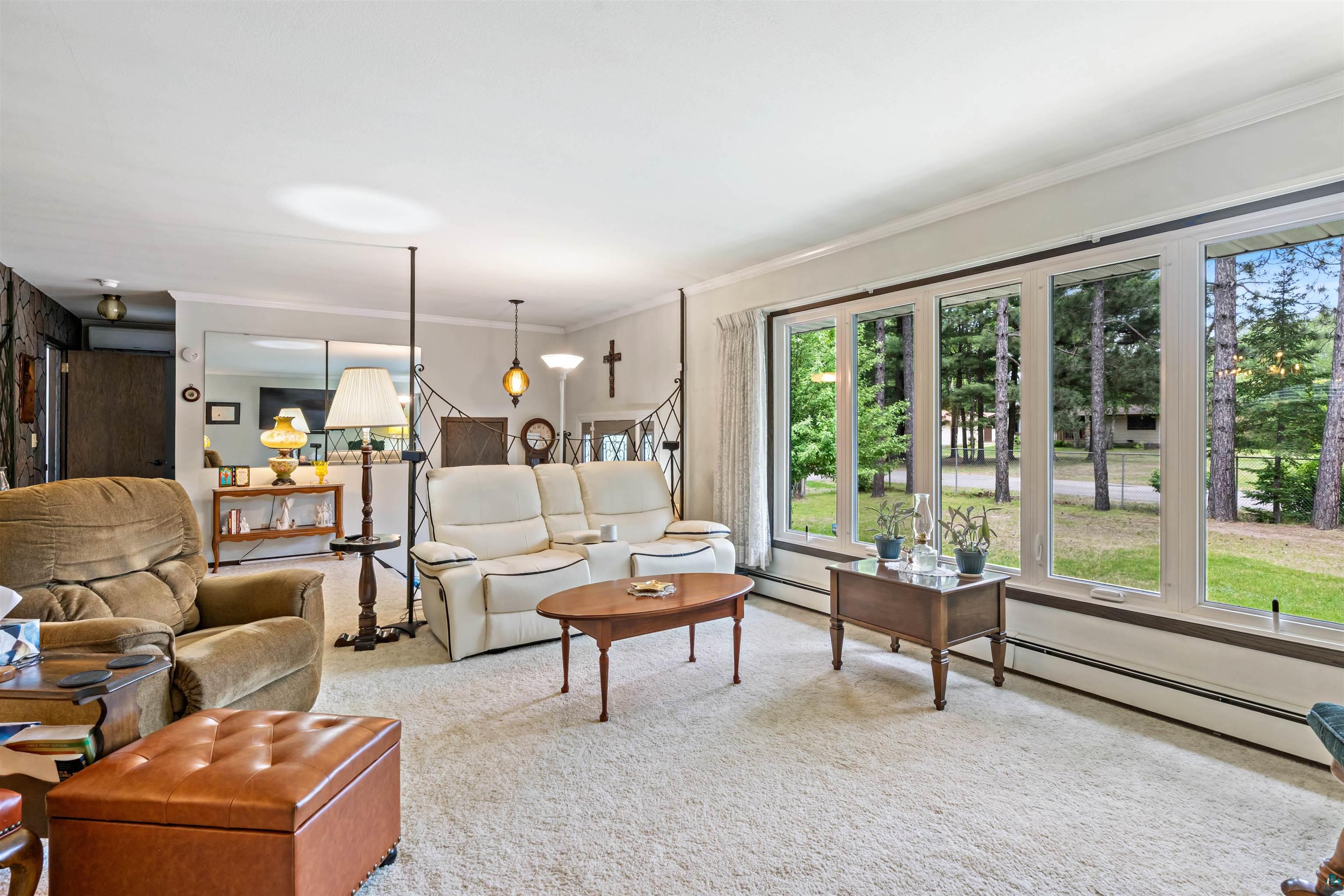 3975 Long Lake Shores Road Eveleth, MN 55734 - Photo 15 of 52 Spacious living area featuring large picture windows, plush carpeting, white baseboards, and a built-in shelf unit