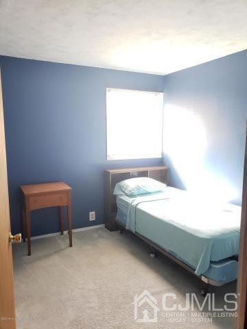 16 Rodney Road East Brunswick, NJ 08816 - Photo 6 of 12 a bedroom with a bed and a chair