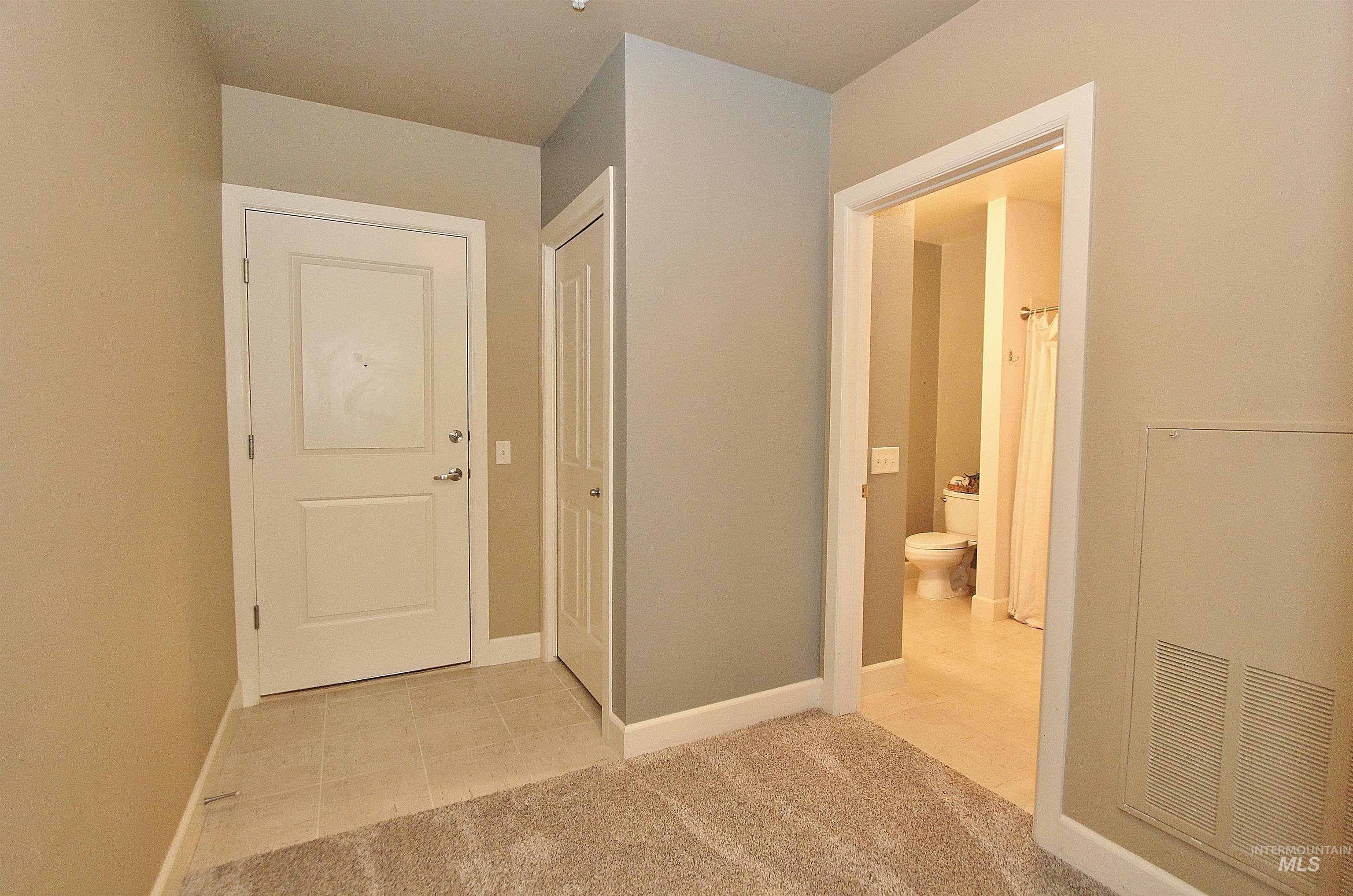 406 South 13th Street, Unit 303 Boise, ID 83702 - Photo 2 of 18 Hall with light colored carpet, a heating unit, and light tile patterned flooring