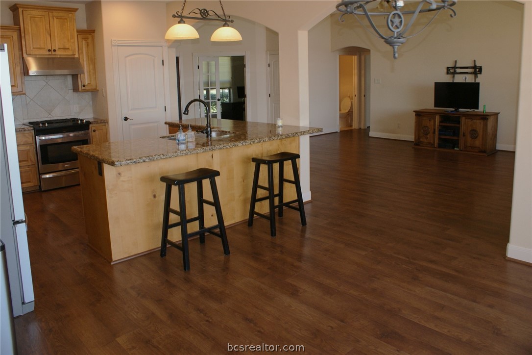 259 Memphis Bell Lane Trinity, TX 75862 - Photo 15 of 50 a kitchen with stainless steel appliances granite countertop a stove top oven a sink a dining table and chairs