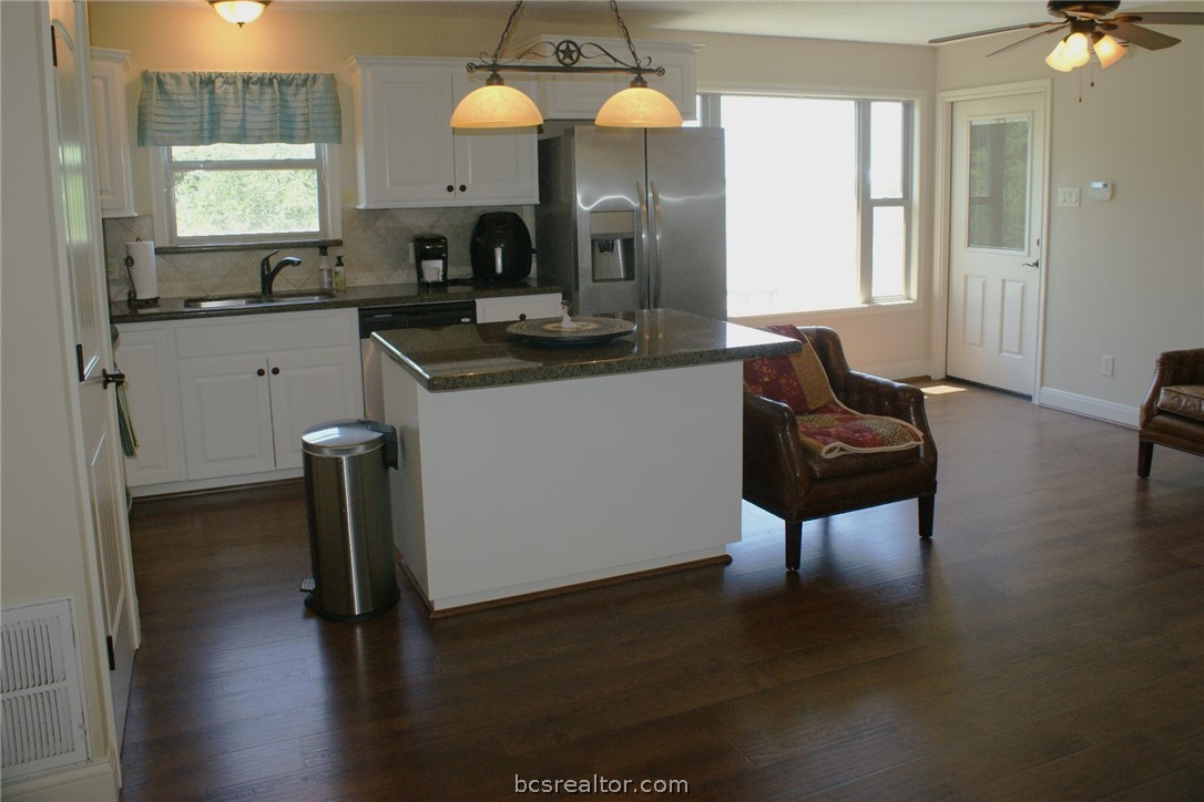 259 Memphis Bell Lane Trinity, TX 75862 - Photo 29 of 50 a kitchen with granite countertop a sink cabinets and wooden floor