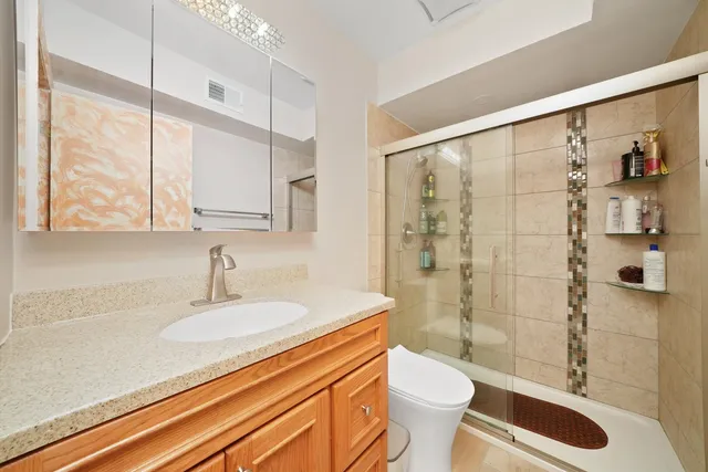 a bathroom with a sink a toilet and shower