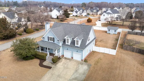 an aerial view of a house with a yard and lake view