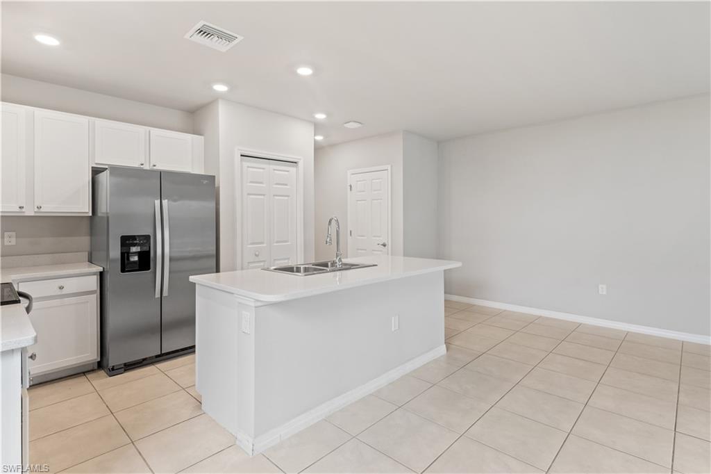 15245 Wildflower Circle Naples, FL 34119 - Photo 11 of 36 a kitchen with stainless steel appliances a refrigerator sink and stove