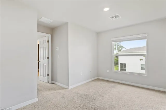 an empty room with a window and a bathroom