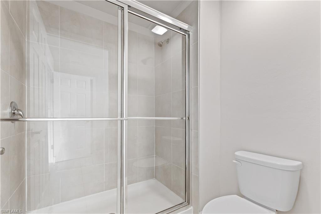 15245 Wildflower Circle Naples, FL 34119 - Photo 19 of 36 a bathroom with a shower a toilet and a sink