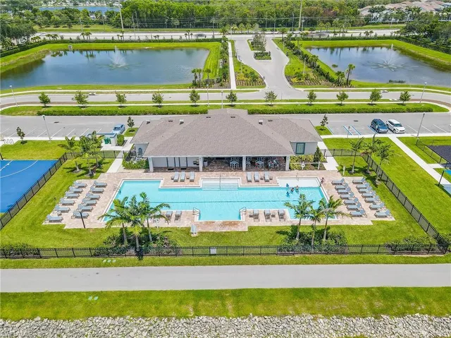 an aerial view of a swimming pool with lawn chairs and plants