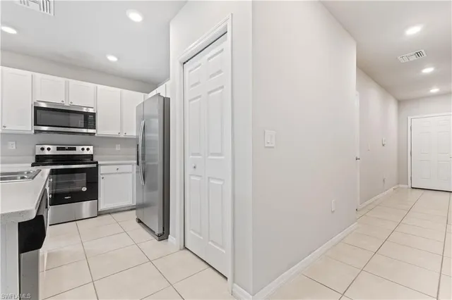 a kitchen with stainless steel appliances granite countertop a refrigerator and a stove top oven