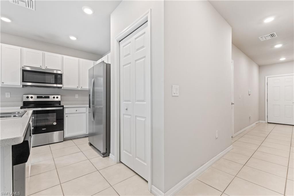 15245 Wildflower Circle Naples, FL 34119 - Photo 6 of 36 a kitchen with stainless steel appliances granite countertop a refrigerator and a stove top oven