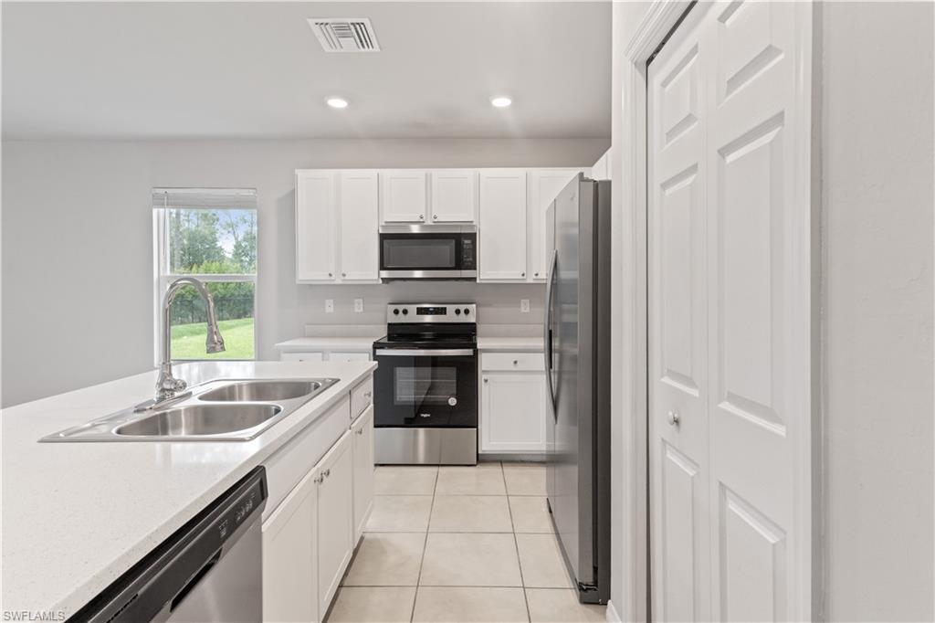 15245 Wildflower Circle Naples, FL 34119 - Photo 8 of 36 a kitchen with a sink appliances and cabinets