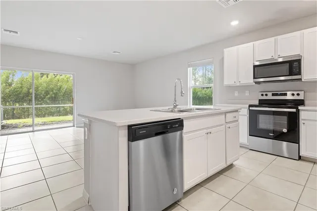 a kitchen with stainless steel appliances a stove sink microwave and cabinets