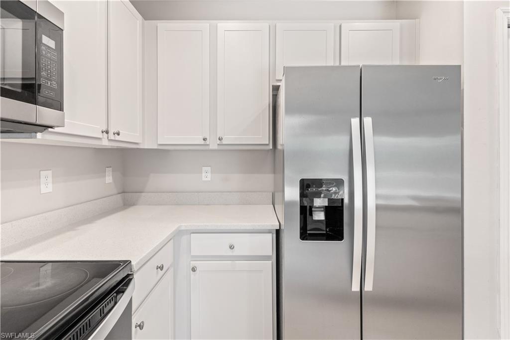 15245 Wildflower Circle Naples, FL 34119 - Photo 10 of 36 a kitchen with metallic refrigerator and cabinets