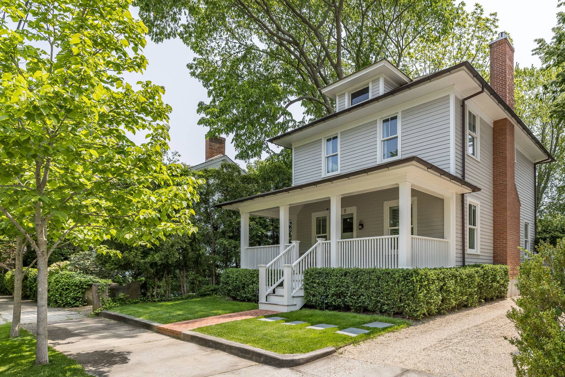 a view of a white house with large windows and a small yard