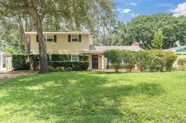 a view of a house with backyard and a tree