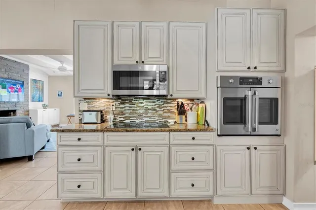 a kitchen with stainless steel appliances granite countertop a stove a sink and a white cabinets
