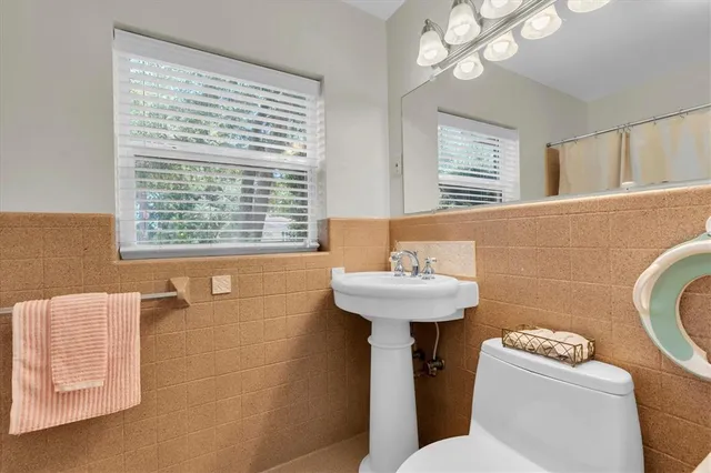 a bathroom with a sink a toilet and a window