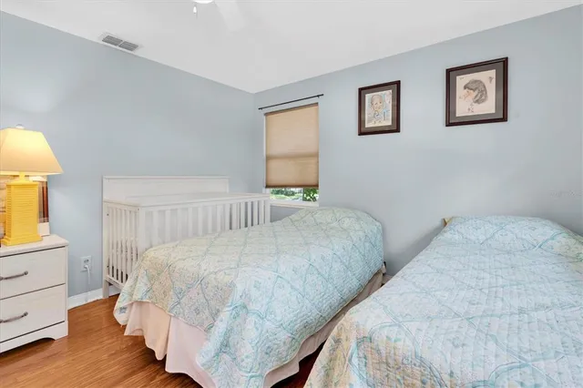 a bedroom with a bed and a lamp on dresser