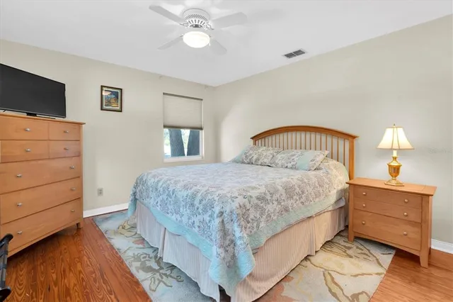 a bedroom with a bed and a flat tv screen on dresser