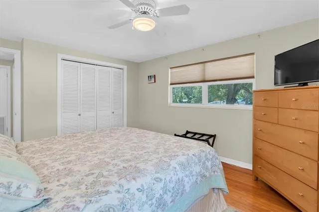 a bedroom with a bed and a flat tv screen on dresser