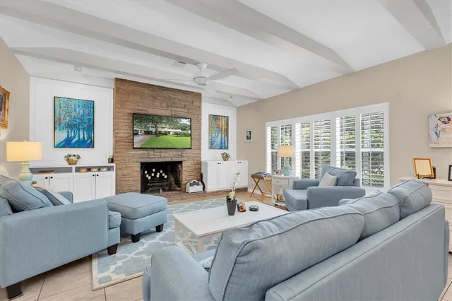 a living room with furniture a fireplace and a large window